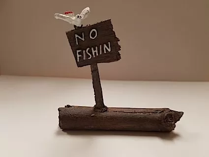 Just Plain Folks "No Fishin" Sign on Log